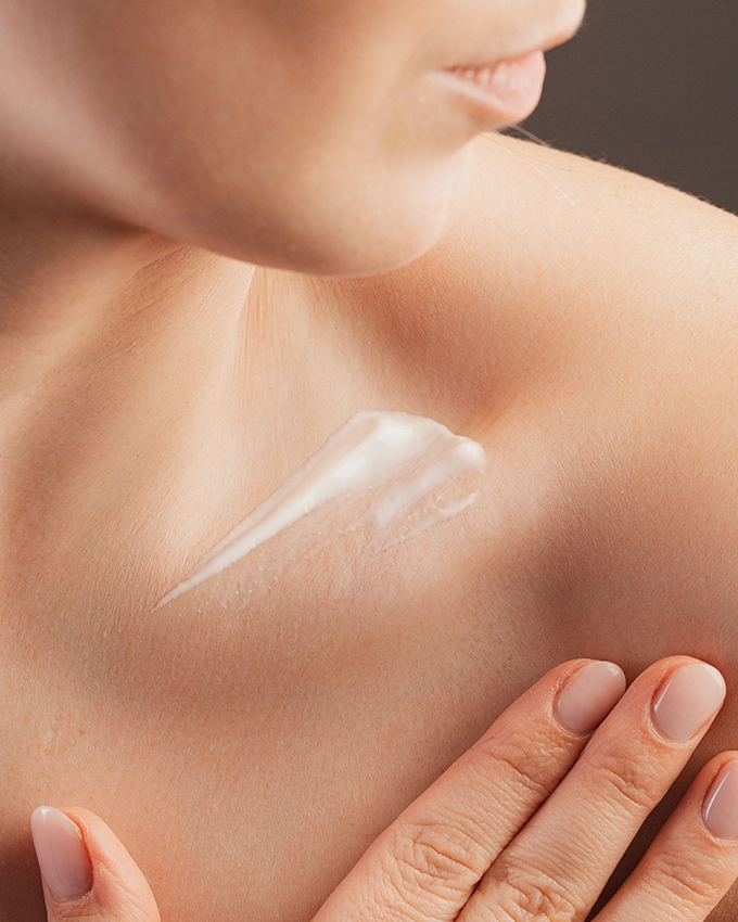 Frau trägt Trawenmoor Hautpflege auf ihr Dekollete auf